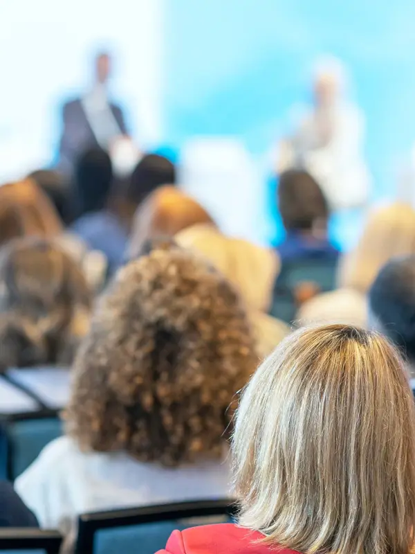 People Looking At A Panel Of Speakers