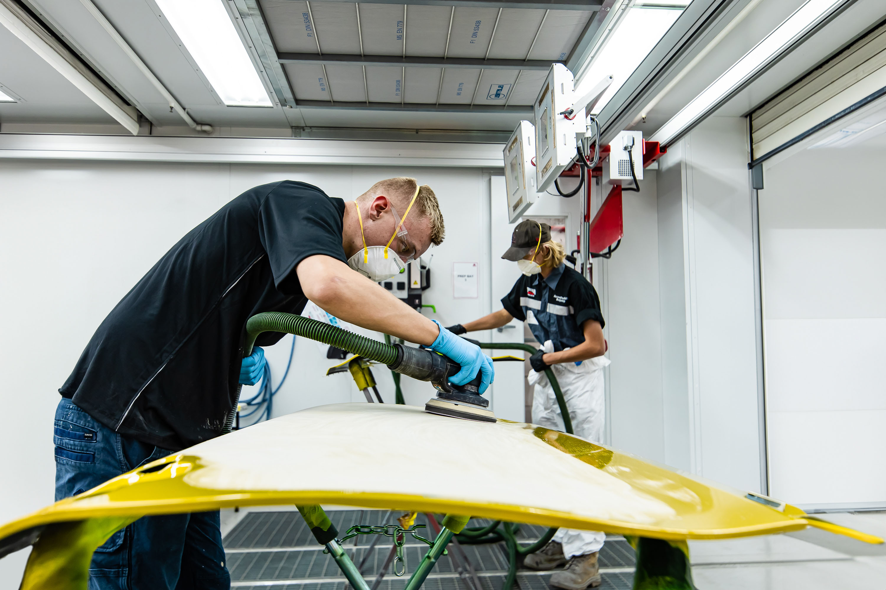 Apprentices Wearing Face Masks And Gloves Sand Vehicle Panels