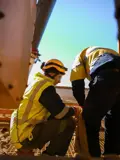 Two People In Safety Attire Working Together Outside