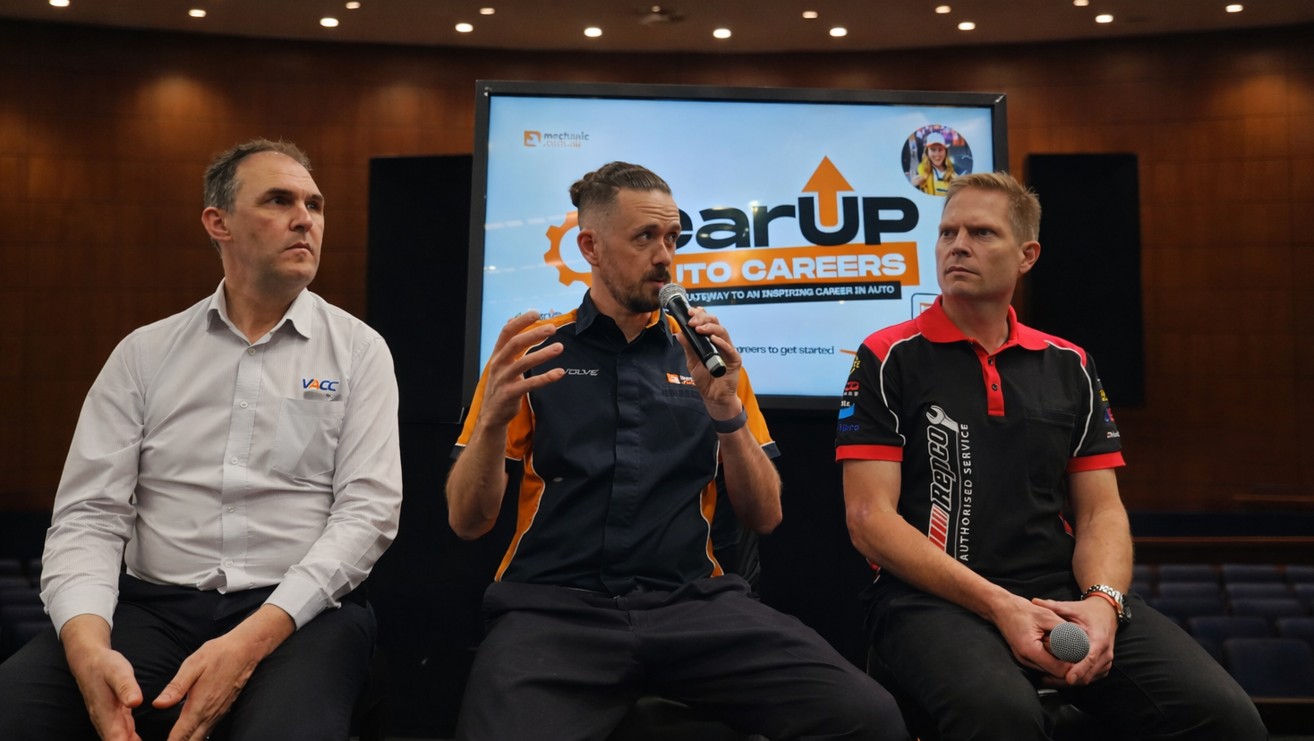 3 men on stage in a discussion