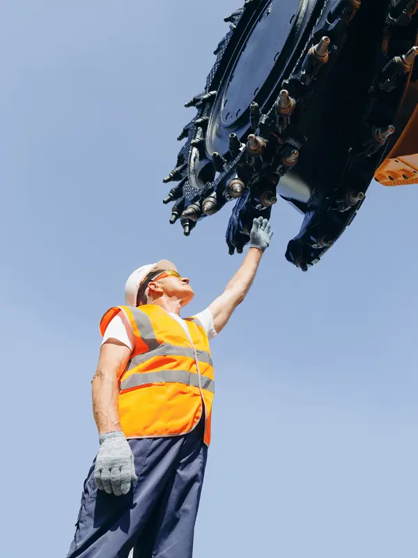 Mining worker adjusts drilling equipment