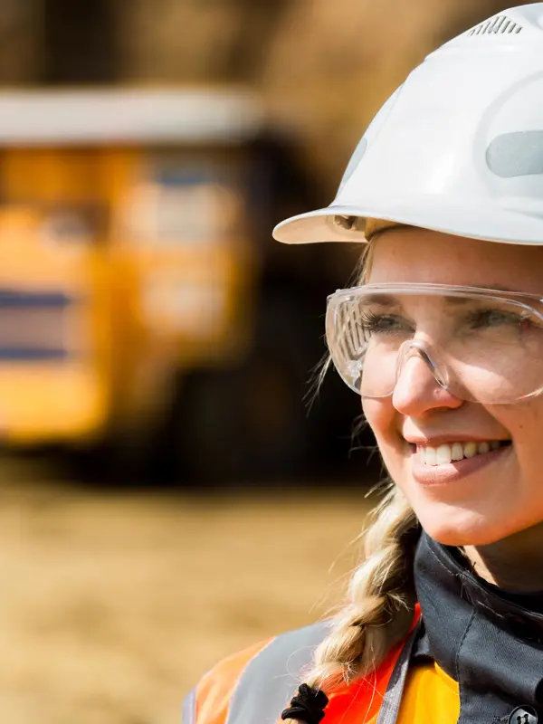 Smiling Worker Wearing Hard Hat And Safety Glasses In Mining Setting