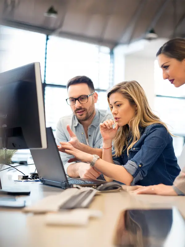 People Sitting Around A Computer
