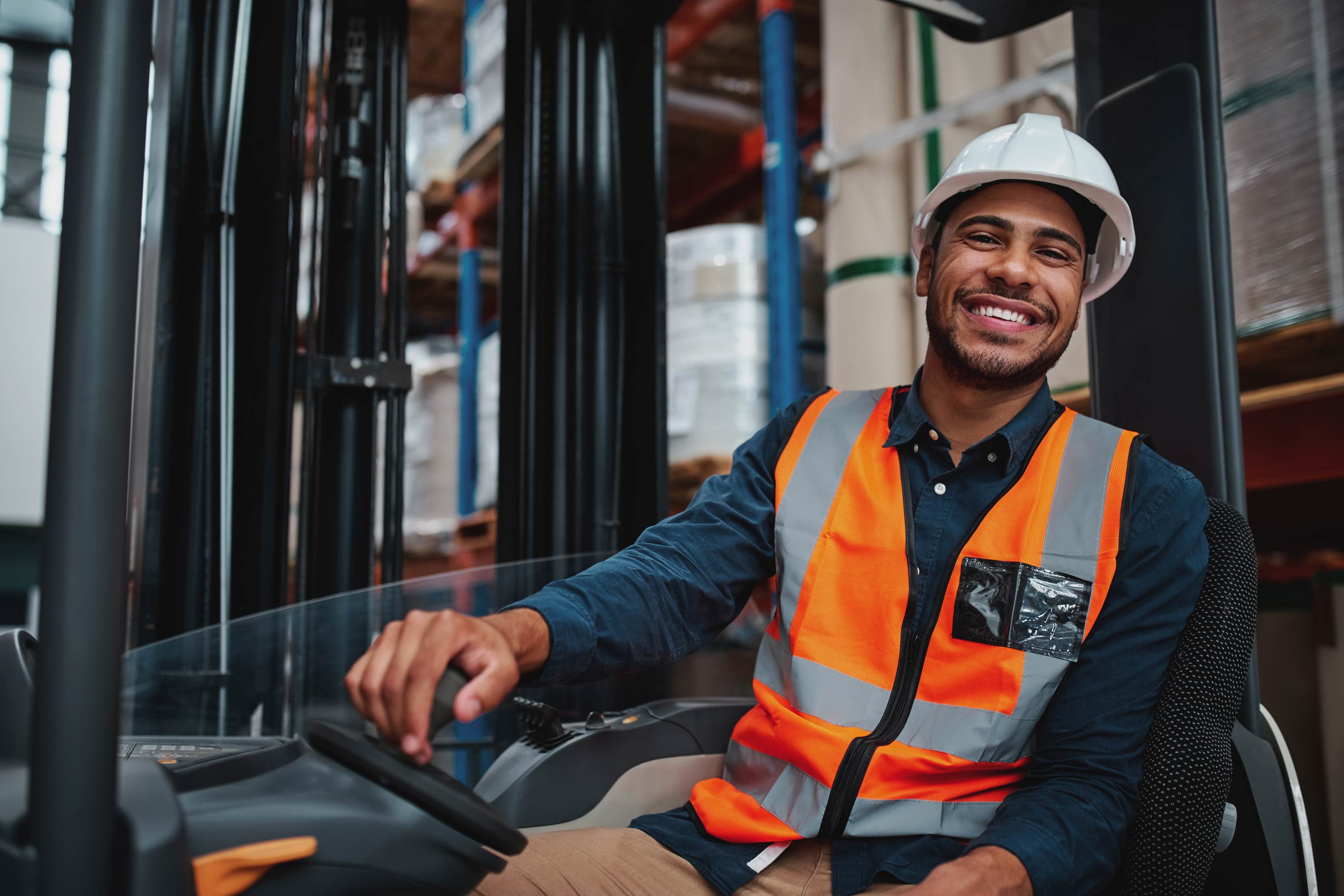 Smiling Worker Wearing Hard Hat And Hi Vis Operates A Forklift