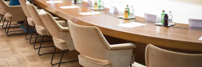 People In A Room Seated Around An Oval Table